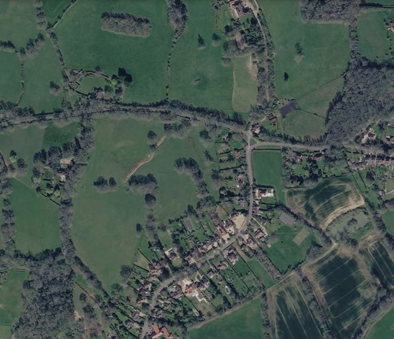 Aerial view of Cox Green, showing the lane, houses and surrounding fields and woodland